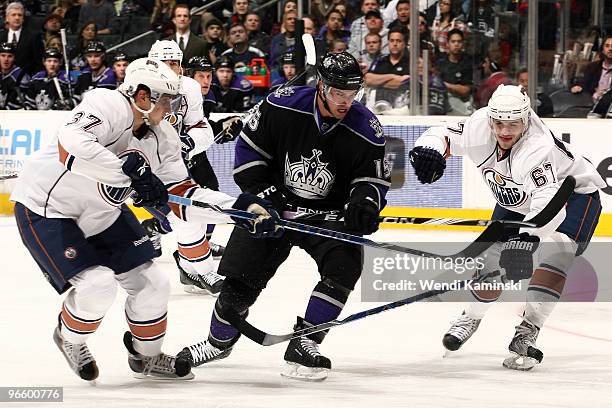 Brad Richardson of the Los Angeles Kings skates between Denis Grebeshkov and Gilbert Brule of the Edmonton Oilers during their game on February 11,...