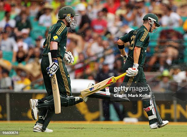Michael Hussey and Michael Clarke of Australia run from the field during a rain delay during the Third One Day International match between Australia...