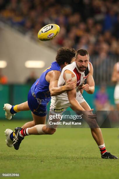 Jarryn Geary of the Saints gets his handball away while being tackled by Josh Kennedy of the Eagles during the round 11 AFL match between the West...