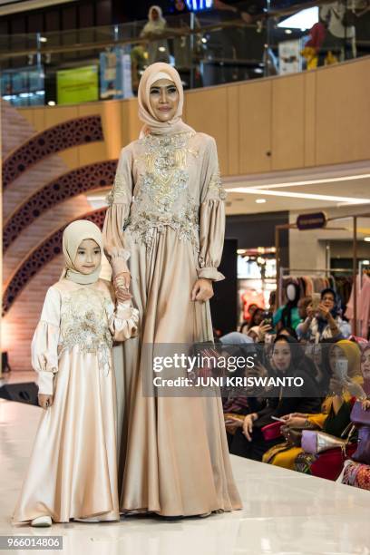 Models present creations from a Muslim fashion house during the holy month of Ramadan in Surabaya on June 2, 2018. - Indonesia, the world's most...