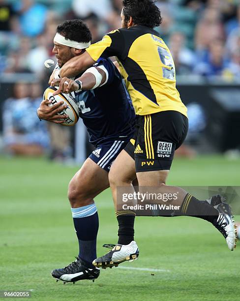 John Afoa of the Blues looses his mouthguard in a tackle from Piri Weepu of the Hurricanes during the round one Super 14 match between the Blues and...