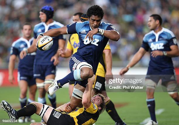 Jerome Kaino of the Blues is tackled by Jason Eaton of the Hurricanes during the round one Super 14 match between the Blues and the Hurricanes at...