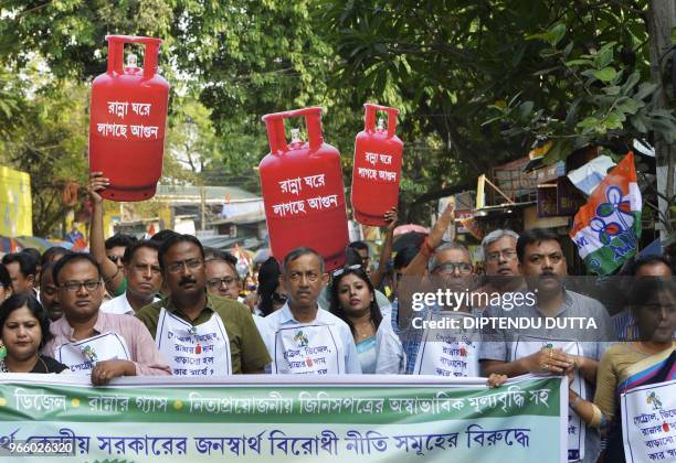 Indian supporters of Trinamool Congress party hold cut-out replicas of LPG cylinder during a protest against the Bharatiya Janata Party lead central...