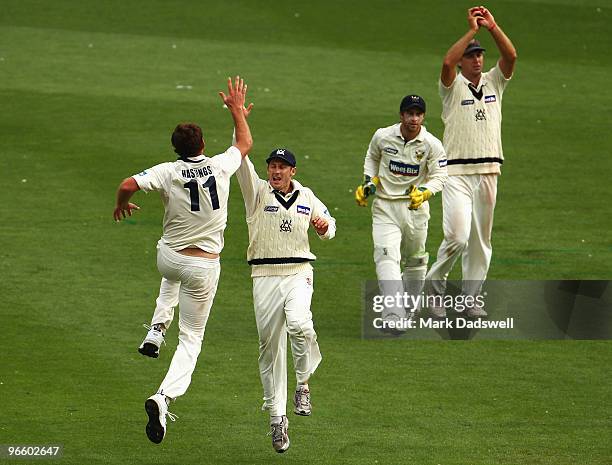 John Hastings of the Bushrangers celebrates the wicket of Peter Forrest of the Blues with his captain David Hussey during day one of the Sheffield...