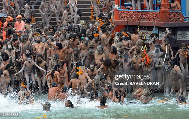 Indian Naga Sadhus - Holy Men - bathe at Har-ki-Pauri at the Ganga River during the First Shahi Snan - Royal Bath - on Maha Shivratri during the...