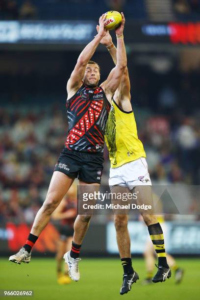 Tom Bellchambers of the Bombers marks the ball against Toby Nankervis of the Tigers during the round 11 AFL match between the Essendon Bombers and...