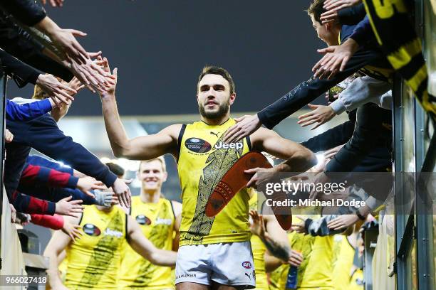 Best on ground Shane Edwards of the Tigers celebrates the win with fans during the round 11 AFL match between the Essendon Bombers and the Richmond...