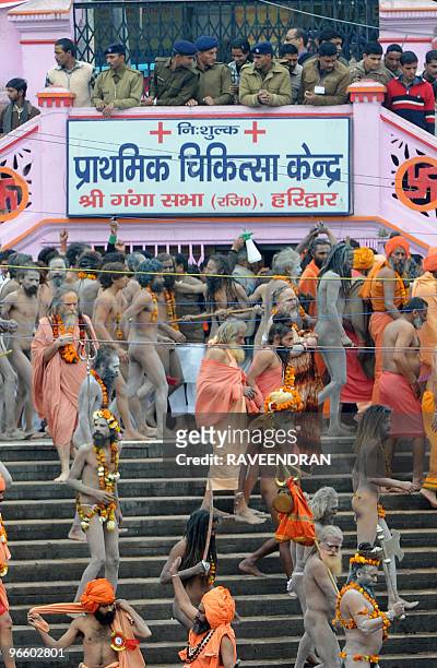 Indian police watch as Naga Sadhus - Holy Men - walk to bathe at Har-ki-Pauri at the Ganga River during the First Shahi Snan - Royal Bath - on Maha...