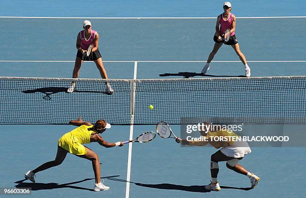 Serena Williams of the US and partner Venus Williams of the US reach for a return against Cara Black of Zimbabwe and Liezel Huber of the US in the...