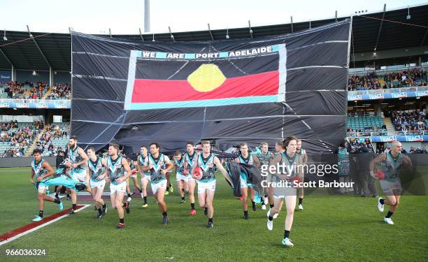 Power players run through their banner during the round 11 AFL match between the Hawthorn Hawks and the Port Adelaide Power at University of Tasmania...