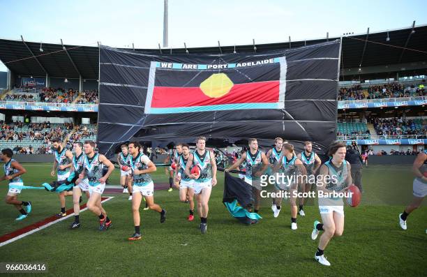 Power players run through their banner during the round 11 AFL match between the Hawthorn Hawks and the Port Adelaide Power at University of Tasmania...