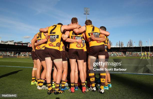 Hawks players form a huddle during the round 11 AFL match between the Hawthorn Hawks and the Port Adelaide Power at University of Tasmania Stadium on...