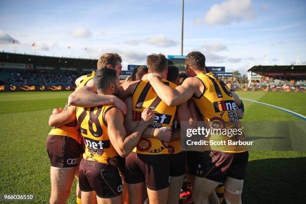 Hawks players form a huddle during the round 11 AFL match between the Hawthorn Hawks and the Port Adelaide Power at University of Tasmania Stadium on...