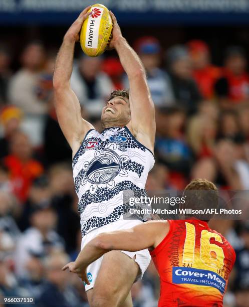 Tom Hawkins of the Cats marks the ball over Rory Thompson of the Suns during the 2018 AFL round 11 match between the Gold Coast Suns and the Geelong...