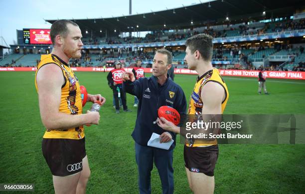 Alastair Clarkson, coach of the Hawks speaks with captain Jarryd Roughead of the Hawks and Liam Shiels of the Hawks after winning the round 11 AFL...
