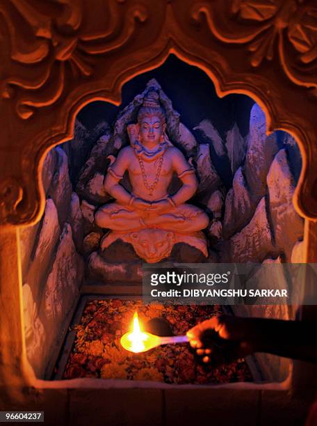 An Indian Hindu priest performs puja - prayers - inside a Lord Shiva temple in Bangalore on February 10, 2010. A portion of the temple complex has...