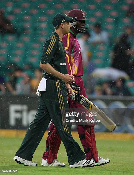 Adam Voges of Australia and Chris Gayle of the West Indies leave the field after rain stopped play during the Third One Day International match...