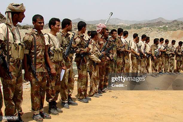 Yemeni troops gather to meet Defence Minister Mohammad Nasser Ahmad during his visit to the frontline in the northern province of Saada on February...