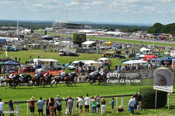 Runners and riders in the first race approach Tattenham Corner on the second day of the Epsom Derby Festival in Surrey, southern England on June 2,...