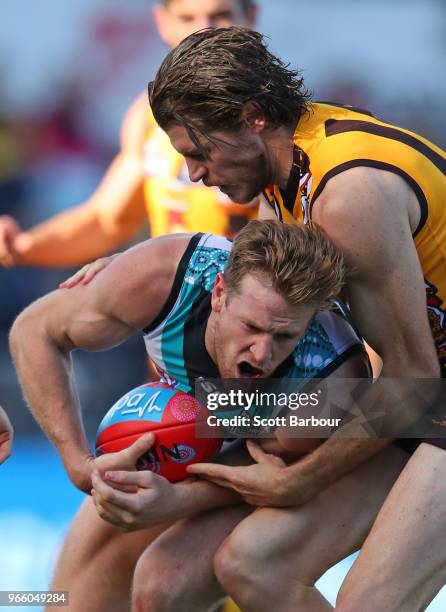 Tom Jonas of the Power is tackled by Isaac Smith of the Hawks during the round 11 AFL match between the Hawthorn Hawks and the Port Adelaide Power at...