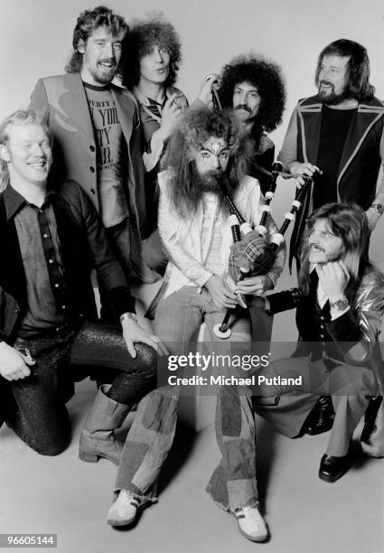 Singer-songwriter and musician Roy Wood plays the bagpipes, surrounded by the other members of English pop group Wizzard, London, December 1974.