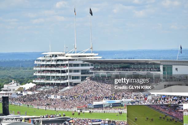 Viewed from the top of the course runners and riders in the first race enter the final furlong on the second day of the Epsom Derby Festival in...