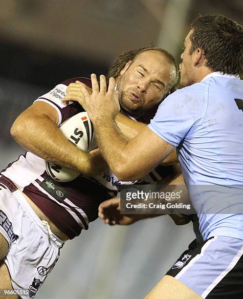 Glenn Stewart of the Sea Eagles is tackled during the NRL trial match between the Cronulla Sutherland Sharks and the Manly Warringah Sea Eagles at...