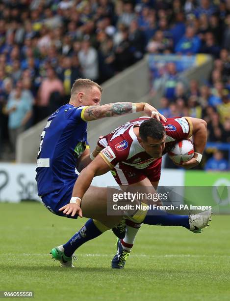 Warrington Wolves' Kevin Brown tackles Wigan Warriors' Ben Flower during the Ladbrokes Challenge Cup, quarter final match at the Halliwell Jones...