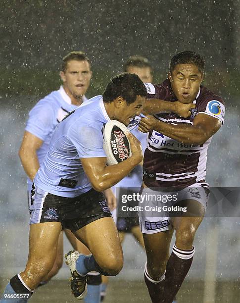 Matthew Wright of the Sharks is tackled by Terence Seu Seu of the Sea Eagles during the NRL trial match between the Cronulla Sutherland Sharks and...