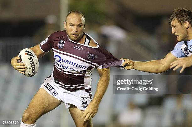 Glenn Stewart of the Sea Eagles is tackled during the NRL trial match between the Cronulla Sutherland Sharks and the Manly Warringah Sea Eagles at...