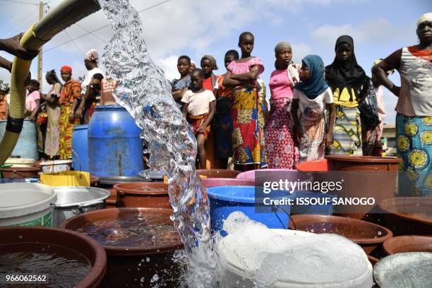 Worker of the National Office of Drinking Water distributes water to the population on June 2, 2018 in a district of Bouake, central Ivory Coast,...