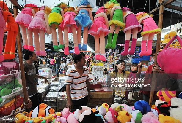 Young girl points her finger at Indonesian-made colourful dolls on display at a street stall in Jakarta on February 1, 2010. Statistics agency...