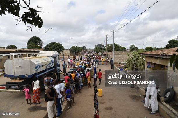 Worker of the National Office of Drinking Water distributes water to the population on June 2, 2018 in a district of Bouake, central Ivory Coast,...