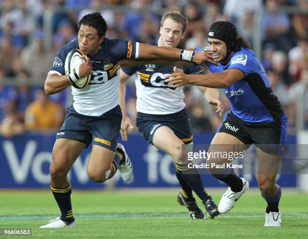 Christian Lealiifano of the Brumbies breaks a tackle by Joshua Tatupu of the Force during the round one Super 14 match between the Western Force and...