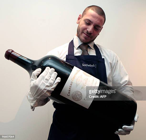 Sotheby's auction house employee holds an 18 litre Melchior wine bottle during a photocall at the auction house in London, on February 12, 2010. The...