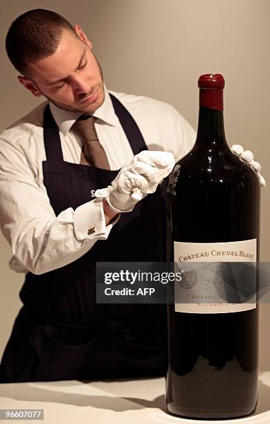 Sotheby's auction house employee poses for pictures with an 18 litre Melchior wine bottle during a photocall at the auction house in London, on...