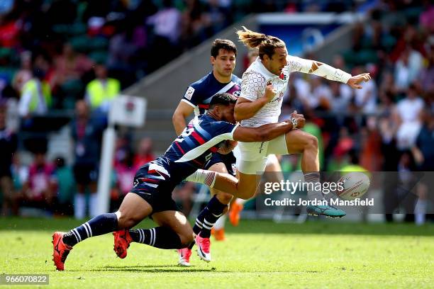 Dan Bibby of England kicks the ball away from Martin Iosefo of the USA on day one of the HSBC London Sevens at Twickenham Stadium on June 2, 2018 in...