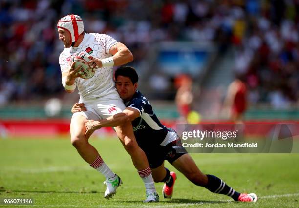 Phil Burgess of England is tackled by Madison Hughes of the USA on day one of the HSBC London Sevens at Twickenham Stadium on June 2, 2018 in London,...