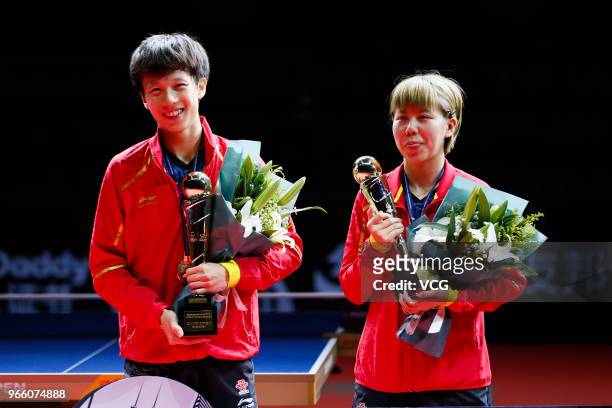 Lin Gaoyuan of China and Chen Xingtong of China pose with trophies after winning the Mixed Doubles final match against Ito Mima of Japan and Masataka...