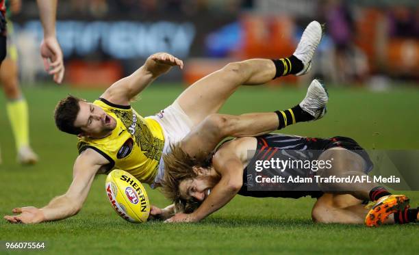 Trent Cotchin of the Tigers and Dyson Heppell of the Bombers compete for the ball during the 2018 AFL round 11 Dreamtime at the G match between the...