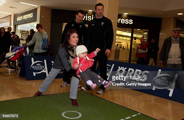 Martha Harrington aided by her Mother Sarah takes part watched by Wales players Matthew Rees and Ian Gough during the RBS Rugby challenge at St...