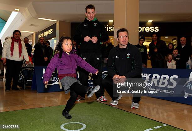 Four year old Jessa takes part watched by Wales players Matthew Rees and Ian Gough during the RBS Rugby challenge at St David's Centre on February...