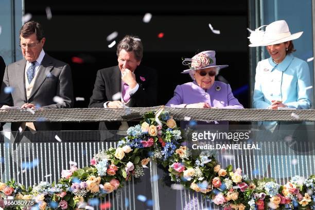 Britain's Queen Elizabeth II and the Queen's racing manager, John Warren attend the second day of the Epsom Derby Festival in Surrey, southern...