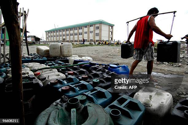 Man carries jerrycans of water in Tondo, Manila on January 31, 2010 where residents have to queue for potable water. Philippine Atmospheric,...