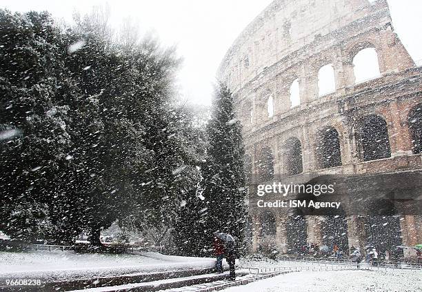 People walk through heavy snow near the Colisseum on February 12, 2010 in Rome, Italy. Rome has been hit by its heaviest snow fall since 1986,...