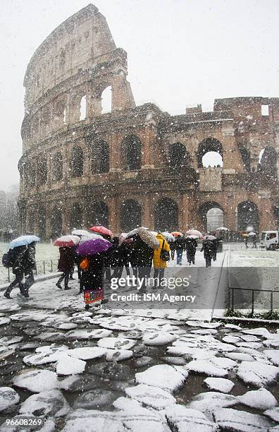 People walk through heavy snow near the Colisseum on February 12, 2010 in Rome, Italy. Rome has been hit by its heaviest snow fall since 1986,...