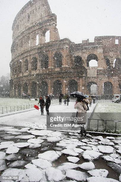 People walk through heavy snow near the Colisseum on February 12, 2010 in Rome, Italy. Rome has been hit by its heaviest snow fall since 1986,...