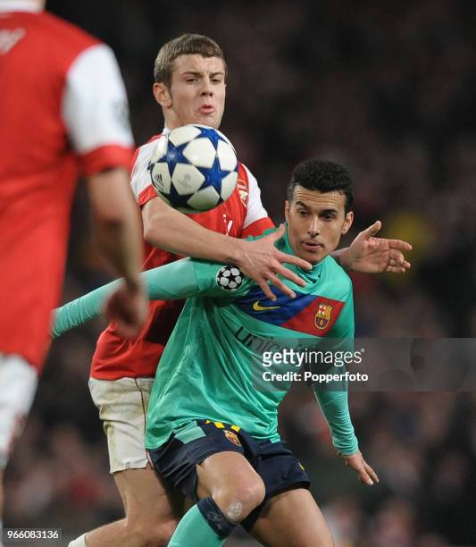 Jack Wilshere of Arsenal challenges Pedro Rodriguez of Barcelona during the UEFA Champions League round of 16 first leg match between Arsenal and...