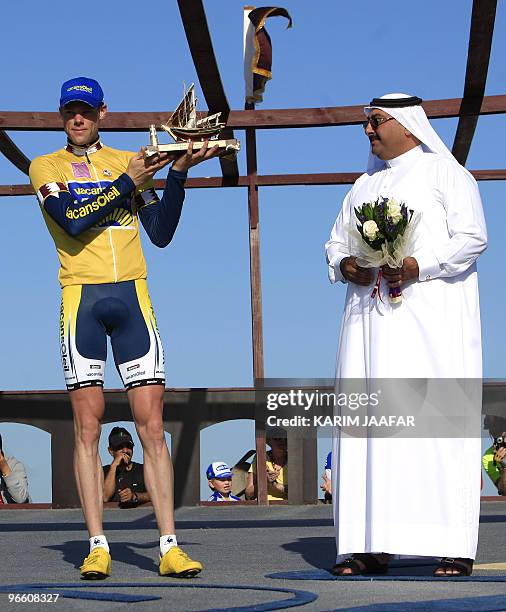 Vacansoleil team rider Wouter Mol of the Netherlands wearing the leader's yellow jersey, celebrates his overall victory on the podium with Sheikh...