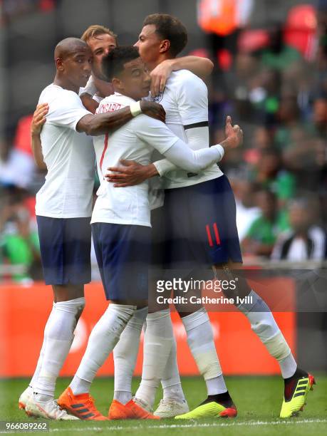 Harry Kane of England celebrates scoring his sides second goal with Ashley Young, Jessie Lingard and Deli Alli of England during the International...